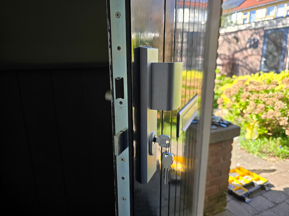 Een KFV meerpuntssluiting en modern kerntrekbeslag vakkundig gemonteerd op een houten voordeur door een inbraakbeveilig specialist.