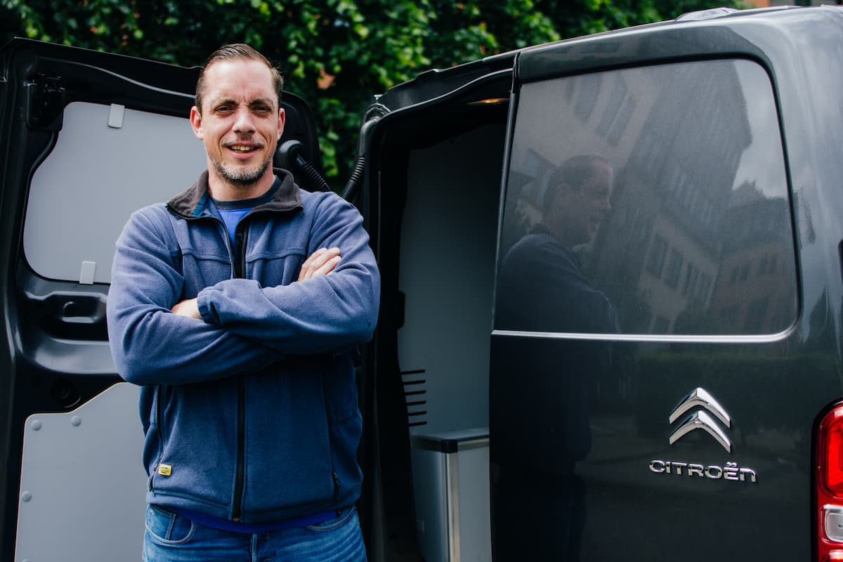 Betrouwbare slotenmaker van Slotenmaker Leidsche Rijn staat glimlachend met de armen over elkaar voor een geopende grijze Citroën service bus.