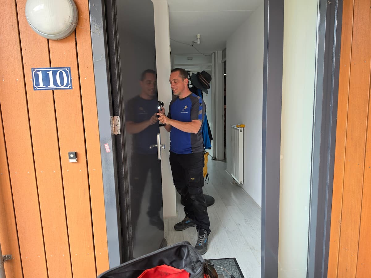 Slotenspecialist Fedi monteert nieuw beslag op een zwarte voordeur in Houten.